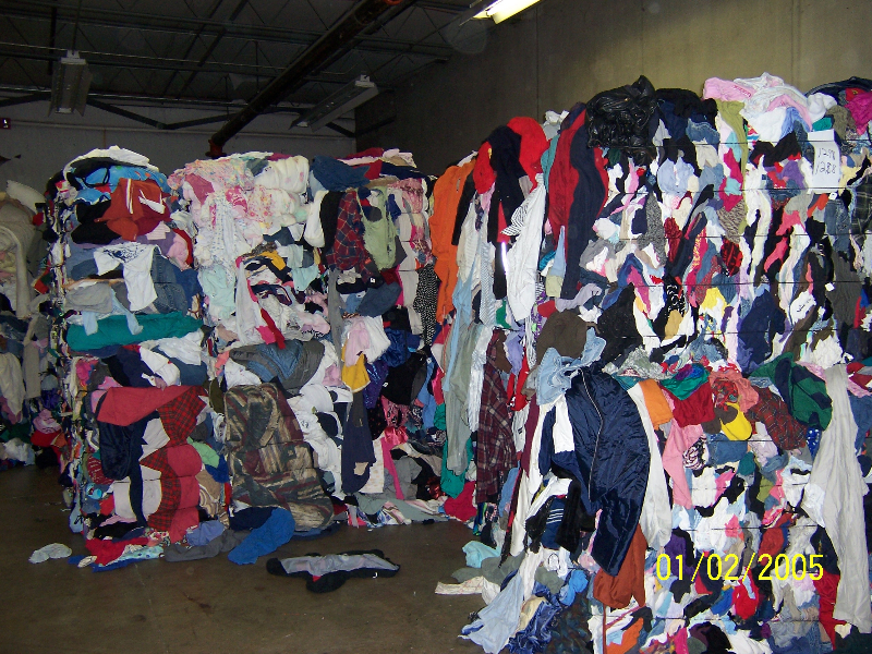 A room filled with lots of clothes and piles of clothing.