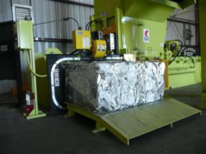 A large metal box is being loaded onto a machine.