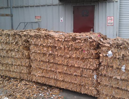 A pile of wood shavings in front of a building.
