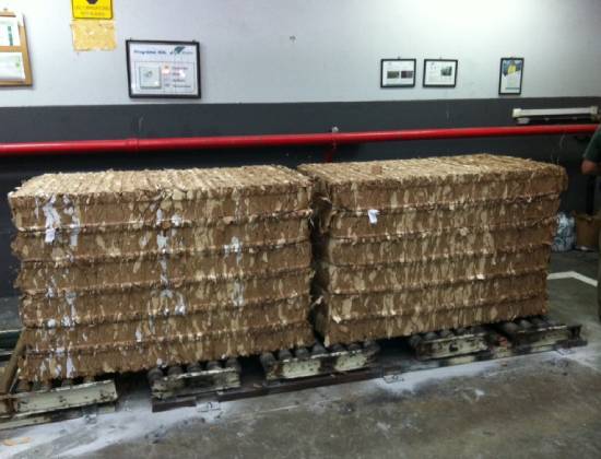 A pallet of cardboard boxes in front of a wall.