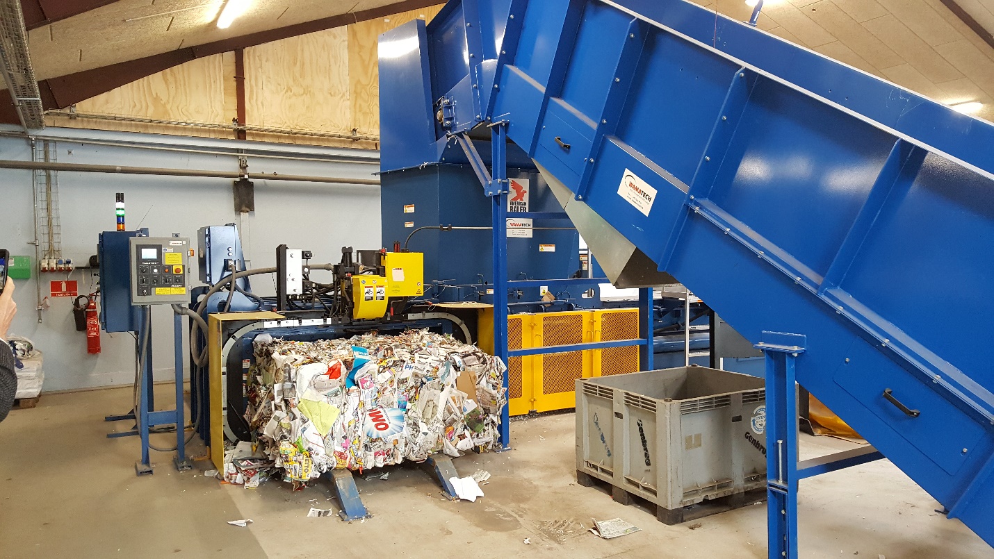 A large blue conveyor belt with many different types of trash.