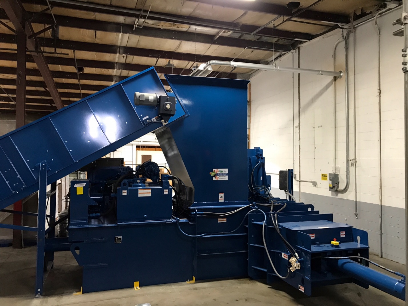 A large blue machine in a warehouse room.