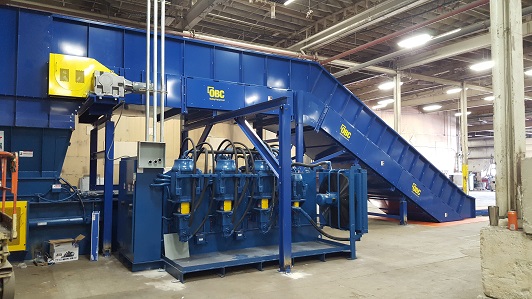 A blue machine with several stacks of metal parts.