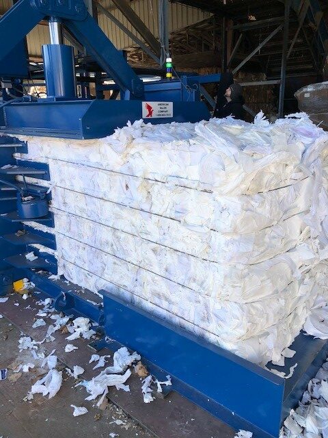 A pile of white paper is being shredded.